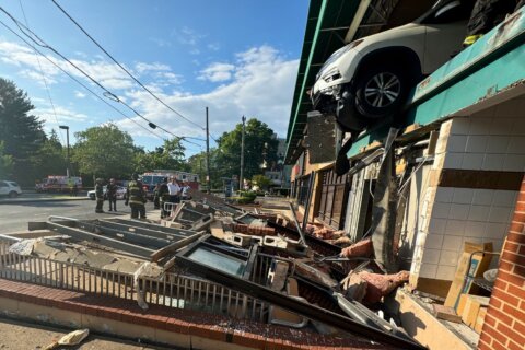 Car crashes through Whole Foods parking garage, dangles over Tenleytown shops