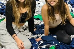 sisters sit on pile of donated jerseys