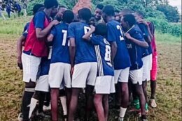 kids in zambia huddle wearing donated jerseys