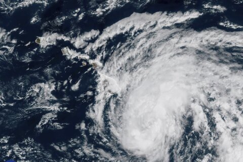 Hone weakens to tropical storm and sweeps past Hawaii, dumping enough rain to ease wildfire fears