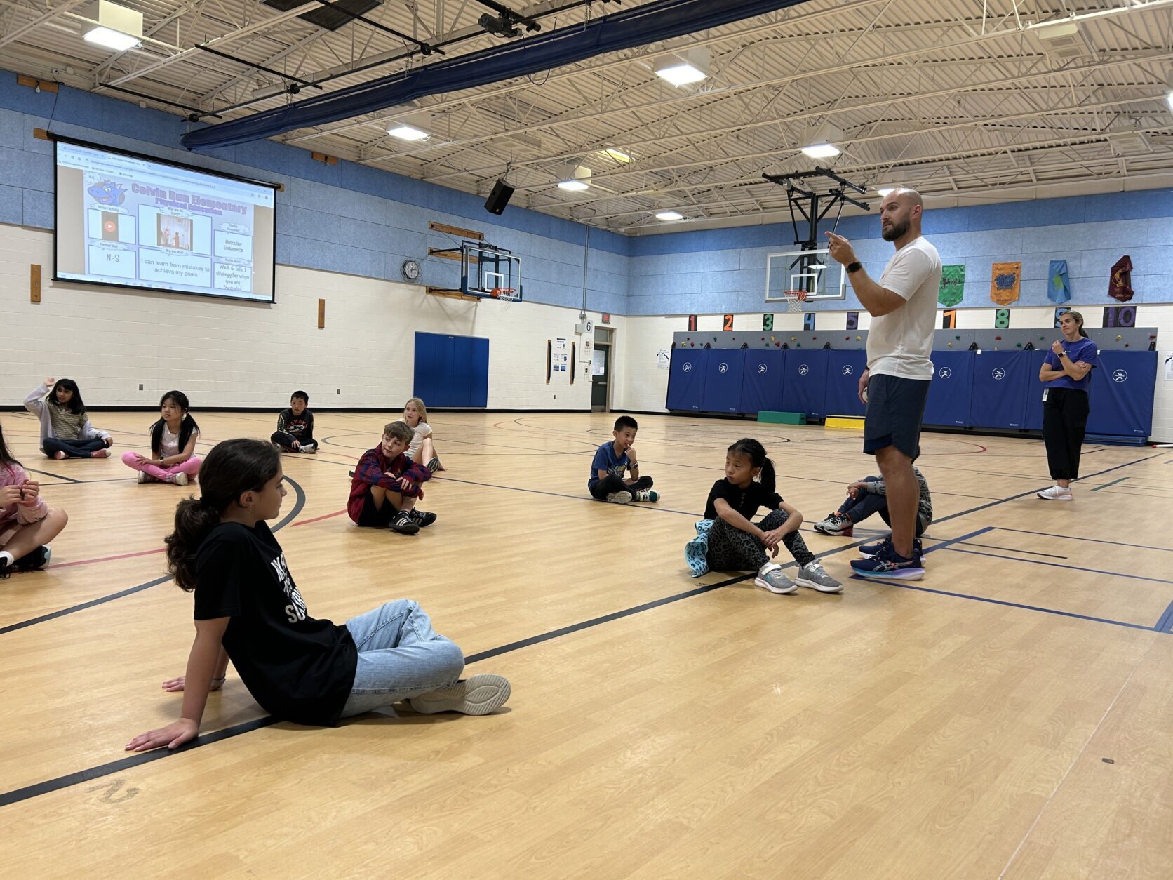 pe teachers teaches kids who are sitting