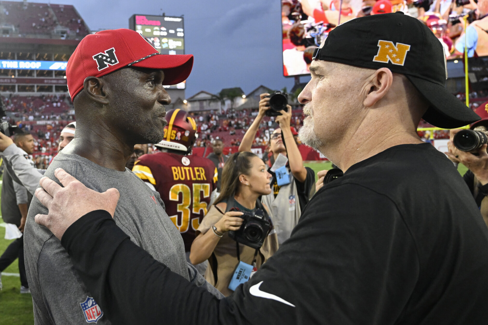 Tampa Bay Buccaneers head coach Todd Bowles, let, and Washington Commanders head coach Dan Quinn greet each other on the field after an NFL football game Sunday, Sept. 8, 2024, in Tampa, Fla. (AP Photo/Jason Behnken)