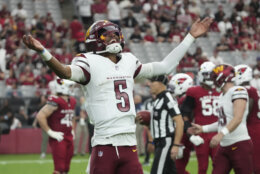 Washington Commanders quarterback Jayden Daniels (5) celebrates a touchdown against the Arizona Cardinals during the second half of an NFL football game, Sunday, Sept. 29, 2024, in Glendale, Ariz. (AP Photo/Rick Scuteri)