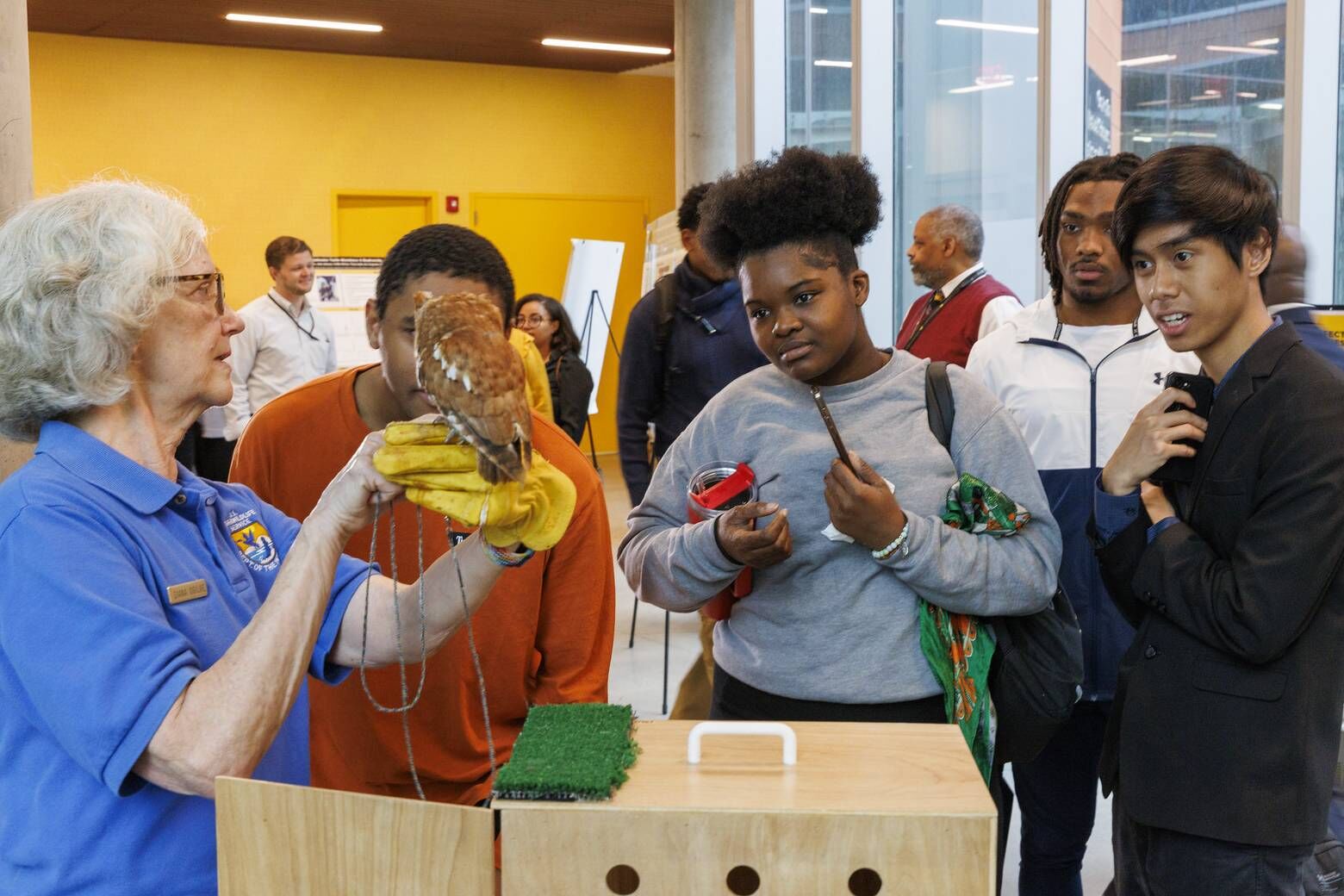 Students interact with Red, an 18-year-old screech owl, during an MOU signing with the U.S. Fish and Wildlife Service between Bowie State University, Alabama A&M and Bethune-Cookman University, Friday, Sept. 27, 2024. (Courtesy Bowie State University)