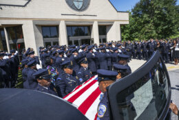 Pall bearers place the casket of D.C. police officer