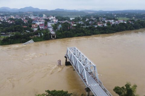 Flooding sweeps away a bus and a bridge collapses in Vietnam as storm deaths rise to 59