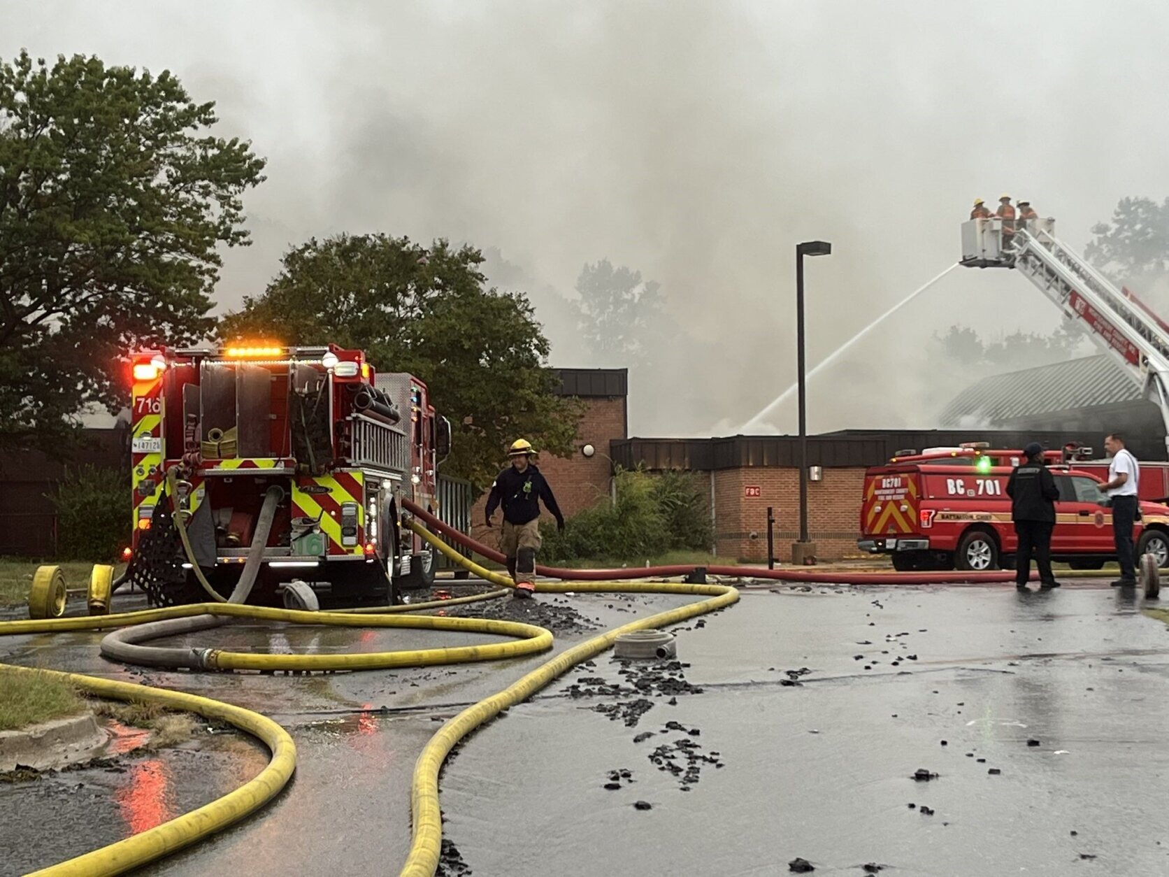 Firefighters fighting fire at closed school building.