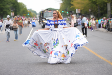 a woman in a traditional white dress dances in the street