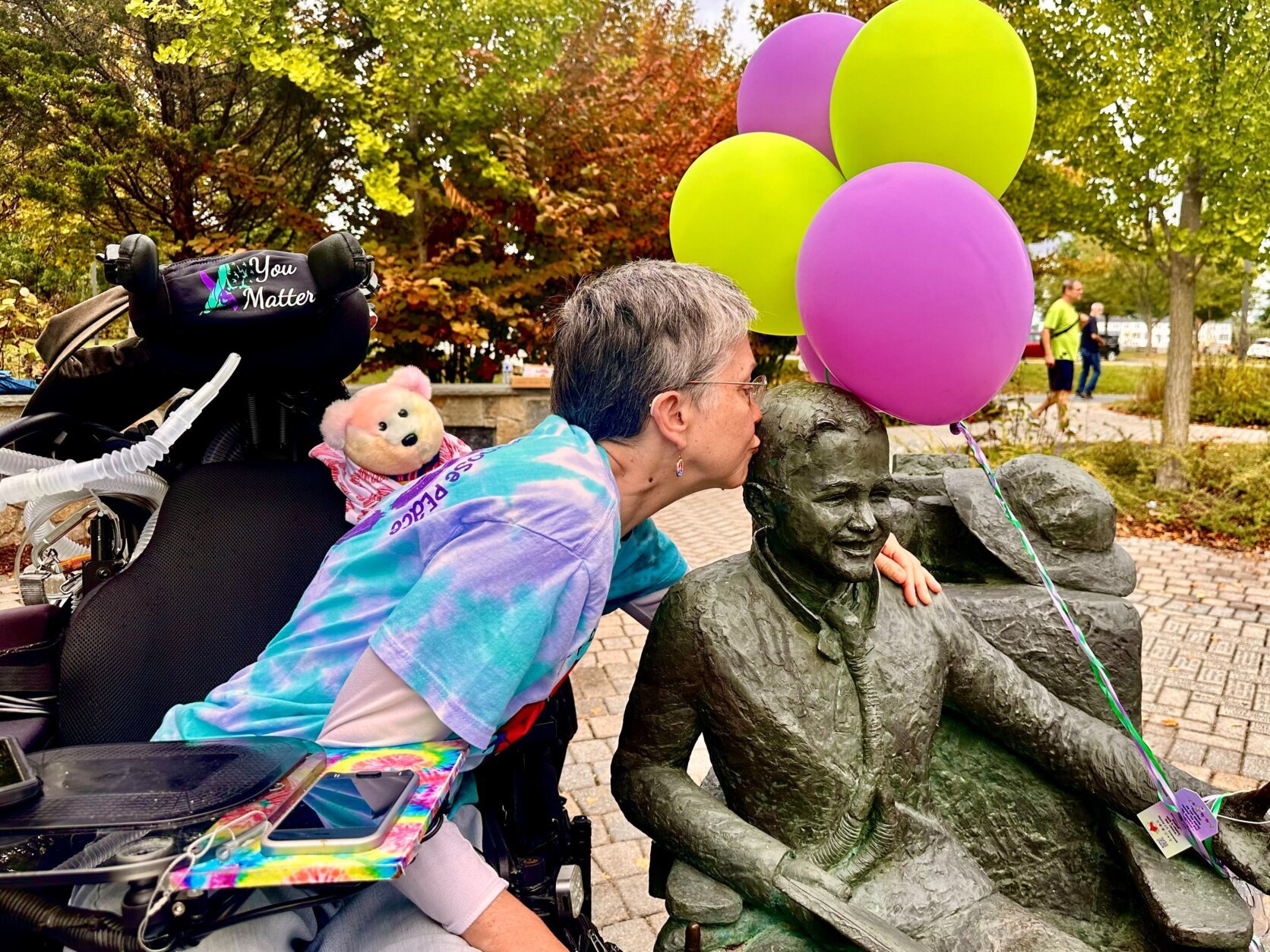 Jeni Stepanek kisses a statue of her son.