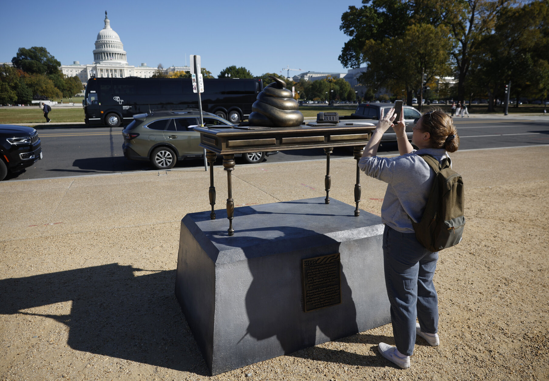 WASHINGTON, DC - OCTOBER 24: A woman takes photos of a satirical art installation that "honors" those who participated in the Jan 6, 2021 riot at the U.S. Capitol on the National Mall in on October 24, 2024 in Washington, DC. The temporary art installation depicts an emoji-style poop on top of then-Speaker of the House Nancy Pelosi’s desk. (Photo by Kevin Dietsch/Getty Images)