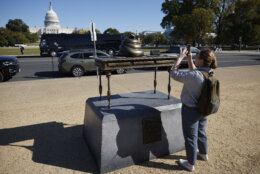 WASHINGTON, DC - OCTOBER 24: A woman takes photos of a satirical art installation that "honors" those who participated in the Jan 6, 2021 riot at the U.S. Capitol on the National Mall in on October 24, 2024 in Washington, DC. The temporary art installation depicts an emoji-style poop on top of then-Speaker of the House Nancy Pelosi’s desk. (Photo by Kevin Dietsch/Getty Images)