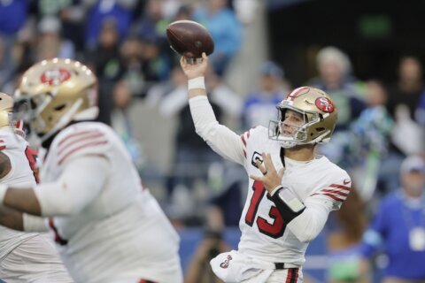 Brock Purdy throws for 3 TDs and the 49ers beat the Seahawks 36-24 to move atop division