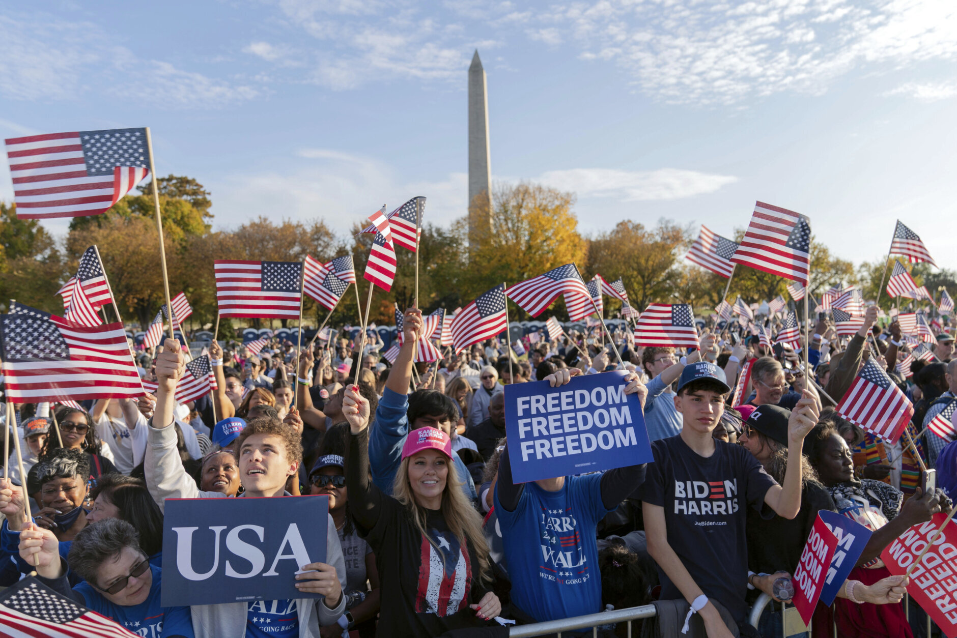 With the Washington Monument in the back ground supporters of Democratic presidential nominee Vice President Kamala Harris wave they American flags as they attend a campaign rally in Washington, Tuesday, Oct. 29, 2024. (AP Photo/Jose Luis Magana)