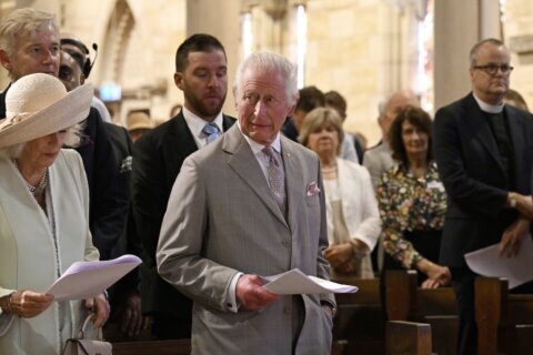 Children greet King Charles III and Queen Camilla outside a Sydney church