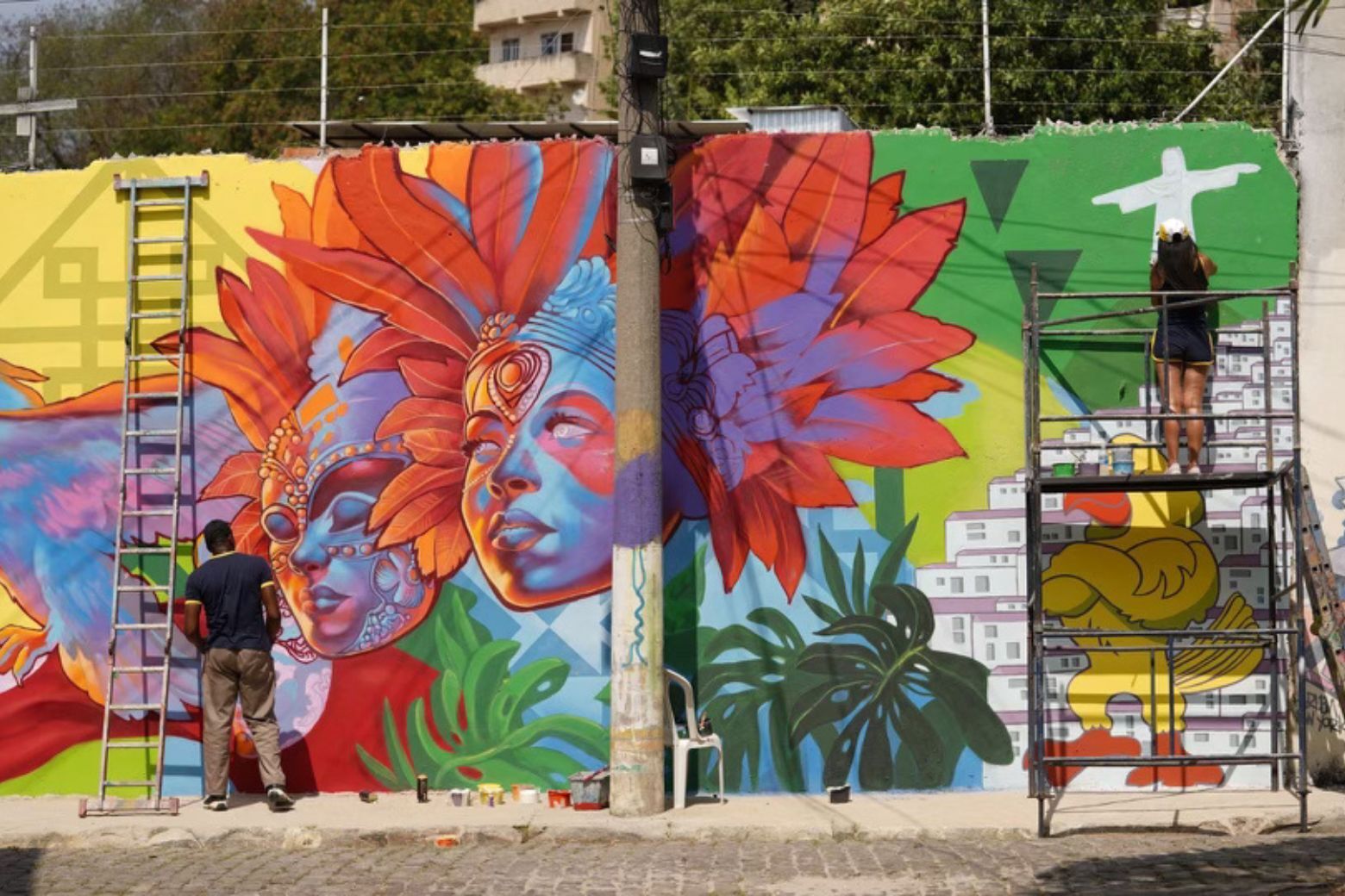 <p>In the Santo Cristo area of Rio, D.C.-based artists Gabriel Lemos, My Ly and Aniekan Udofia are working to create a D.C.-inspired mural.</p>
