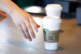 A barista sets down a completed drink in a single-use cup at a Starbucks retail location, Wednesday, June 28, 2023, in Seattle. (AP Photo/Lindsey Wasson)