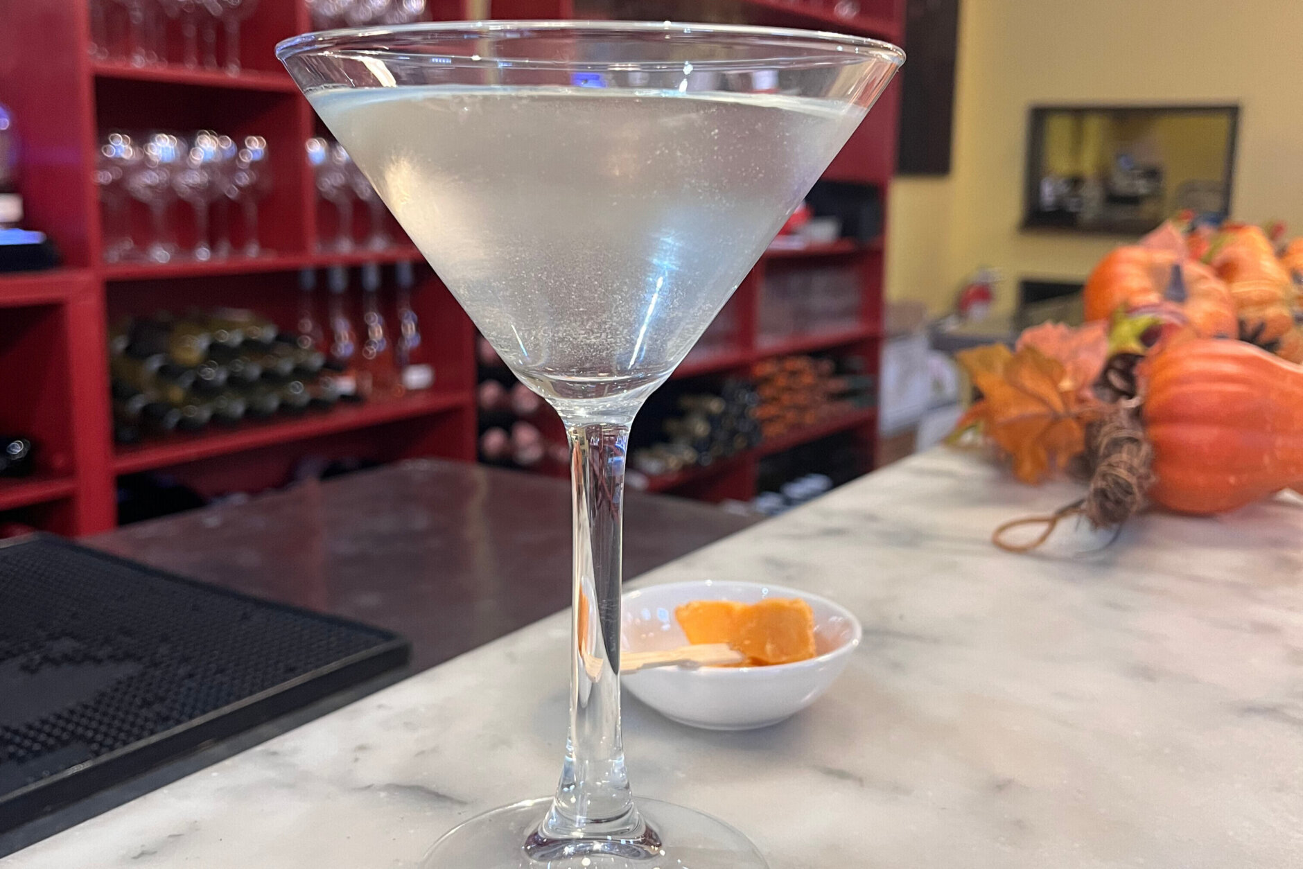 A clear drink appears on a counter in the Cheesetique.