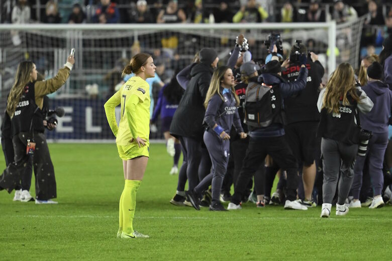 Washington Spirit midfielder Hal Hershfelt, center left, looks on as the Orlando Pride celebrates after winning the NWSL championship soccer game at CPKC Stadium, Saturday, Nov. 23, 2024, in Kansas City, Mo. (AP Photo/Reed Hoffmann)