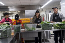 Vice President Kamala Harris, center-right, her grand-nieces Leela Ajagu, center-left, and Amara Ajagu, left, and second gentleman Doug Emhoff, right, celebrate Thanksgiving Day by helping to prepare vegetables at the DC Central Kitchen in Washington Thursday, Nov. 28, 2024. (AP Photo/Ben Curtis)