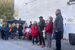 People standing at mural unveiling in D.C.'s Chinatown