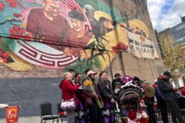 group poses for photo in front of mural