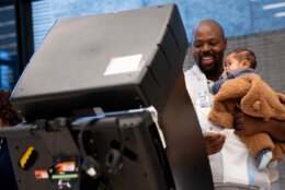 Man holds child voting