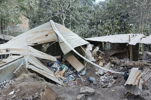 Indonesian rescuers dig through volcanic ash after eruption kills 9 and destroys buildings