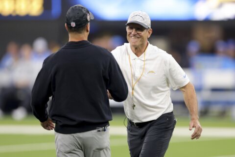 Harbaugh brothers share hug at midfield before facing each other for 3rd time