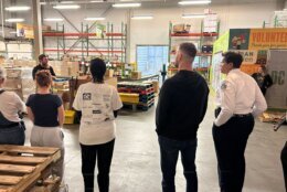 Volunteers in a warehouse putting food into boxes