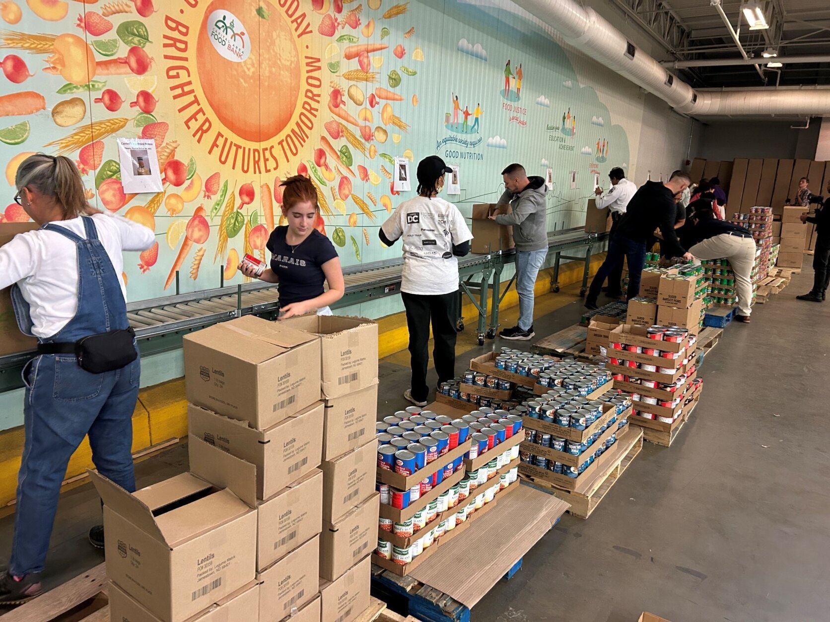 Volunteers in a warehouse putting food into boxes