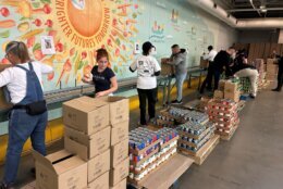 Volunteers in a warehouse putting food into boxes