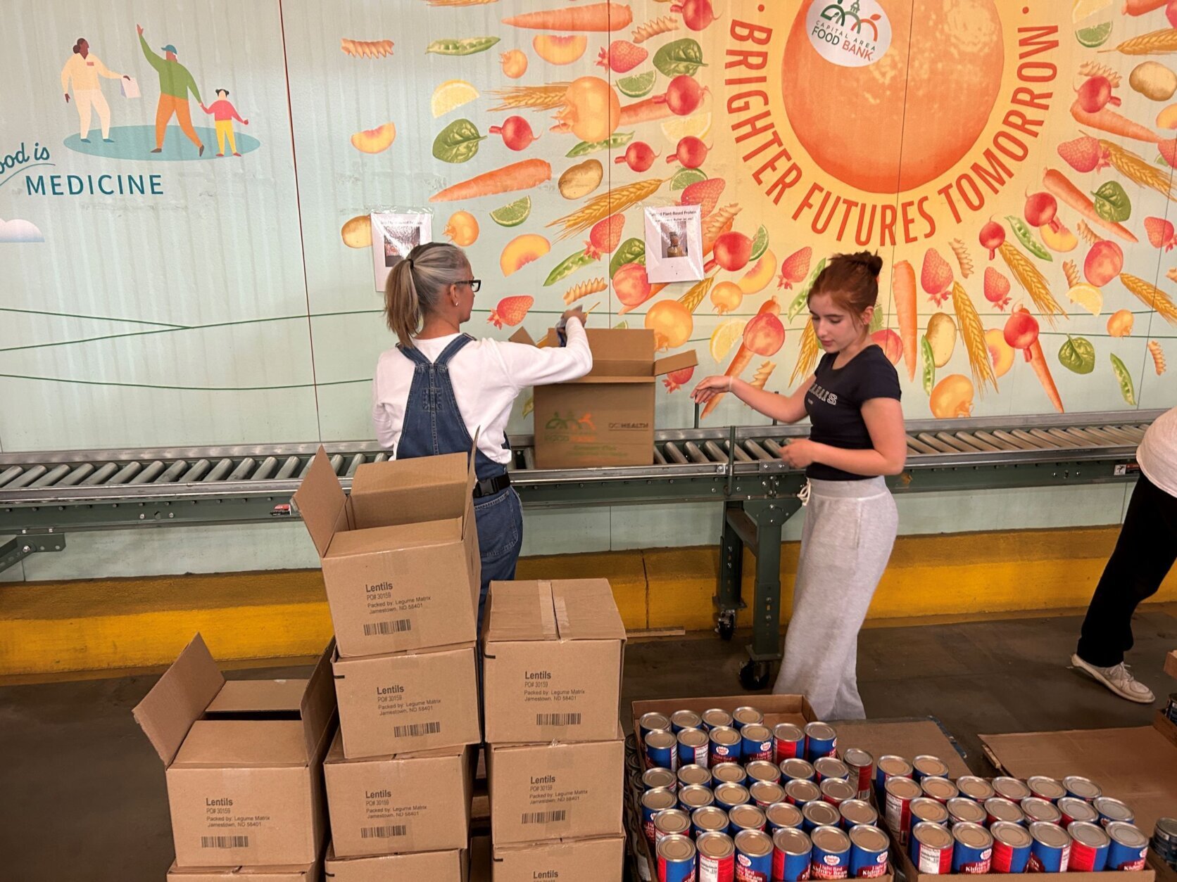 Volunteers in a warehouse putting food into boxes