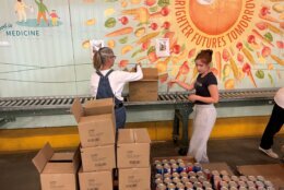 Volunteers in a warehouse putting food into boxes