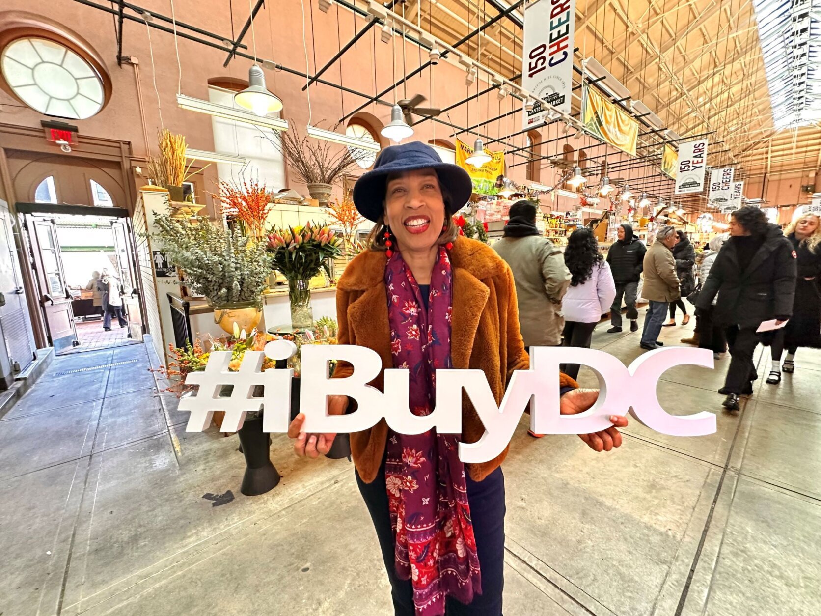 woman holding 'i buy DC' sign