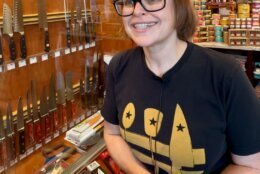 store owner near a wall of knives