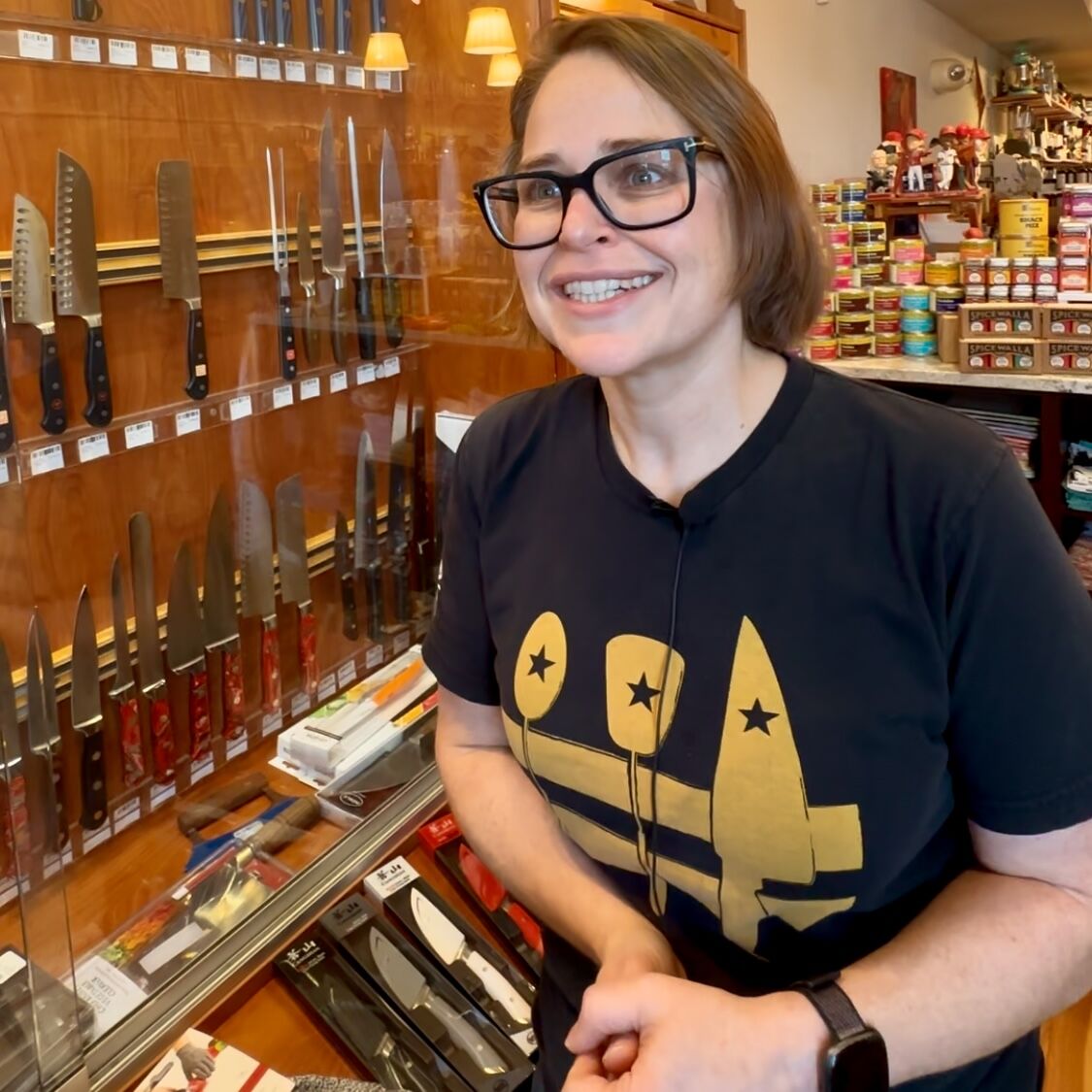 store owner near a wall of knives