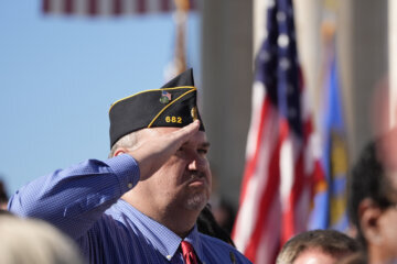 An attendee salutes at the National Veterans Day Observance at the Memorial Amphitheater at Arlington National Cemetery in Arlington, Va., Monday, Nov. 11, 2024. (AP Photo/Mark Schiefelbein)