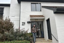 man stands outside apartment