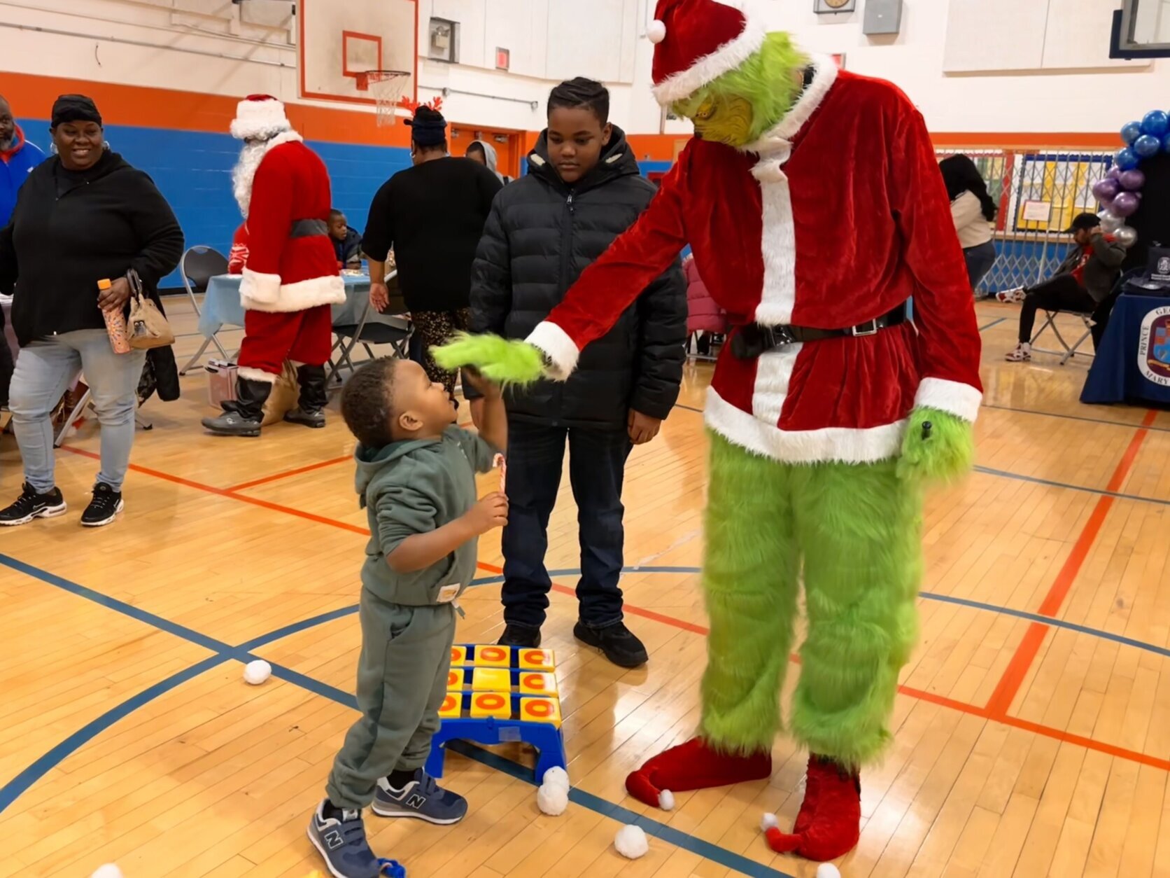 Kid high fives the Grinch during the Toy Giveaway event.