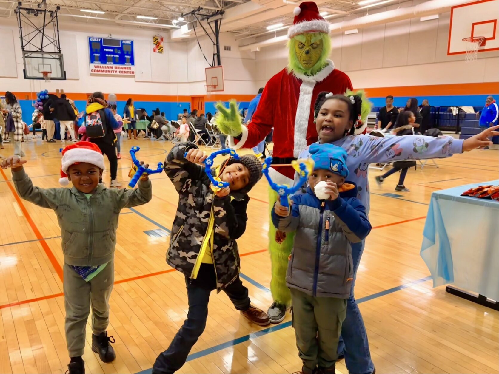 Kids posing with the Grinch during the Toy Giveaway event.