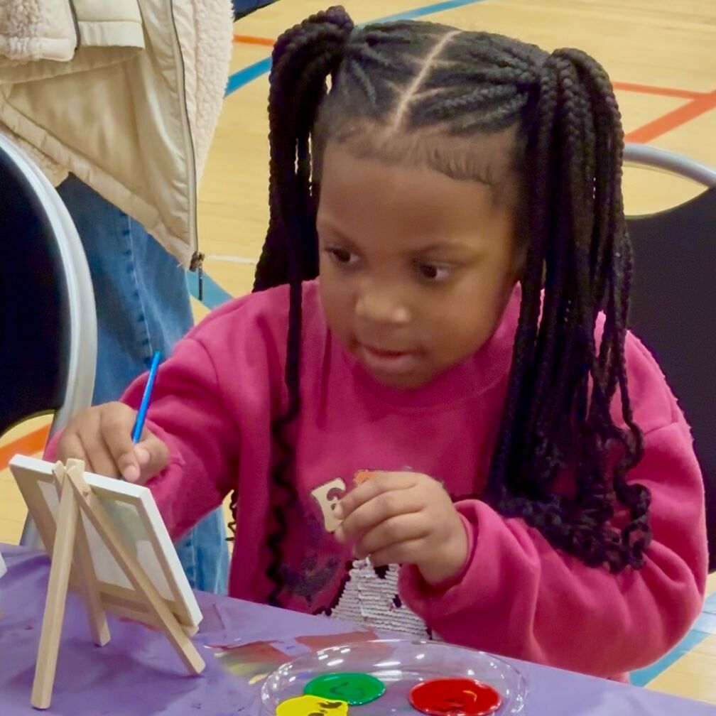 Child painting at toy giveaway event