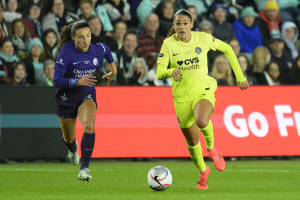 Orlando Pride defender Kerry Abello chasing Washington Spirit forward Trinity Rodman for the soccer ball.