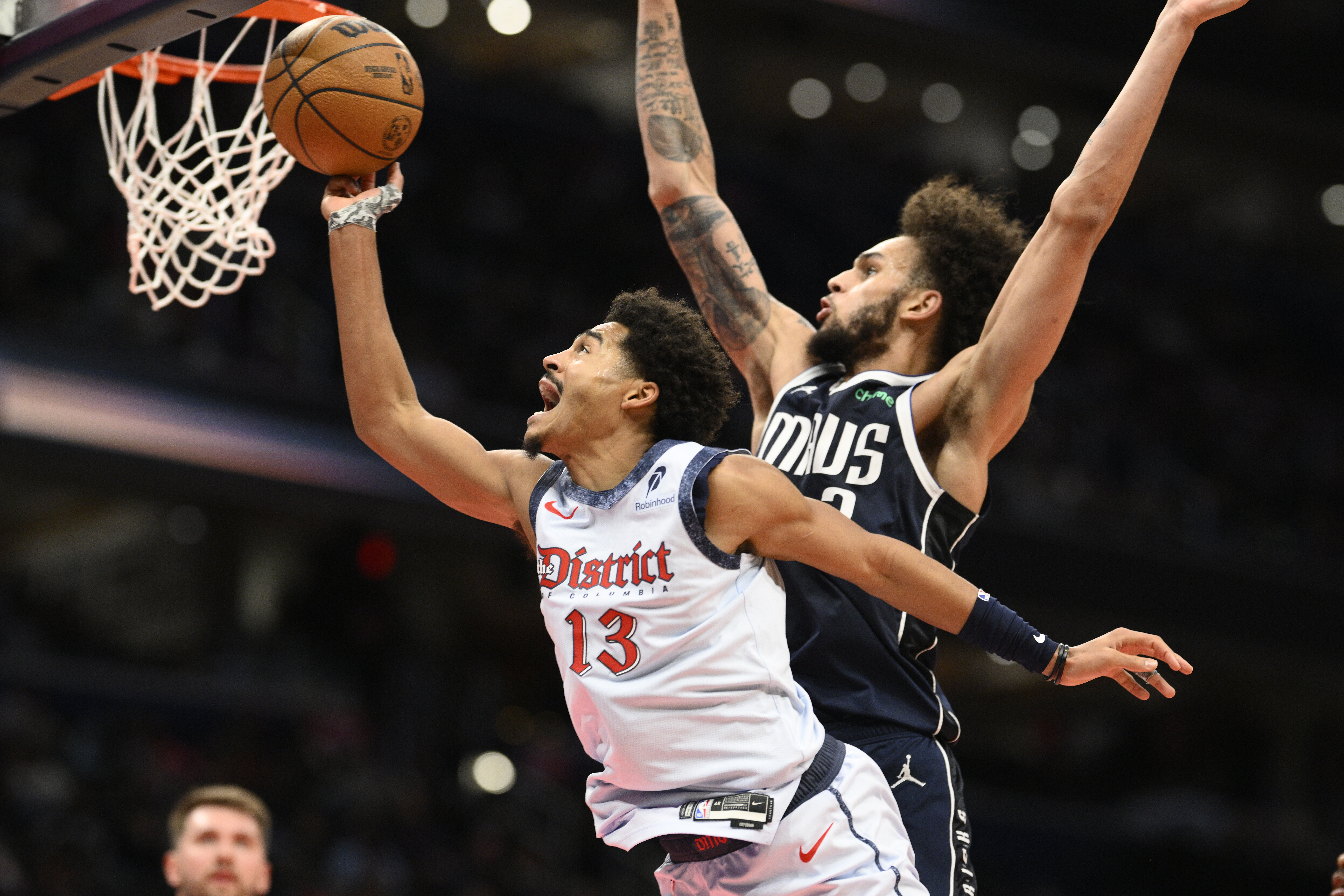 Washington Wizards guard Jordan Poole (13) goes to the basket against Dallas Mavericks center Dereck Lively II, right, during the first half of an NBA basketball game, Thursday, Dec. 5, 2024, in Washington. Lively II was called for a foul on the play. (AP Photo/Nick Wass)