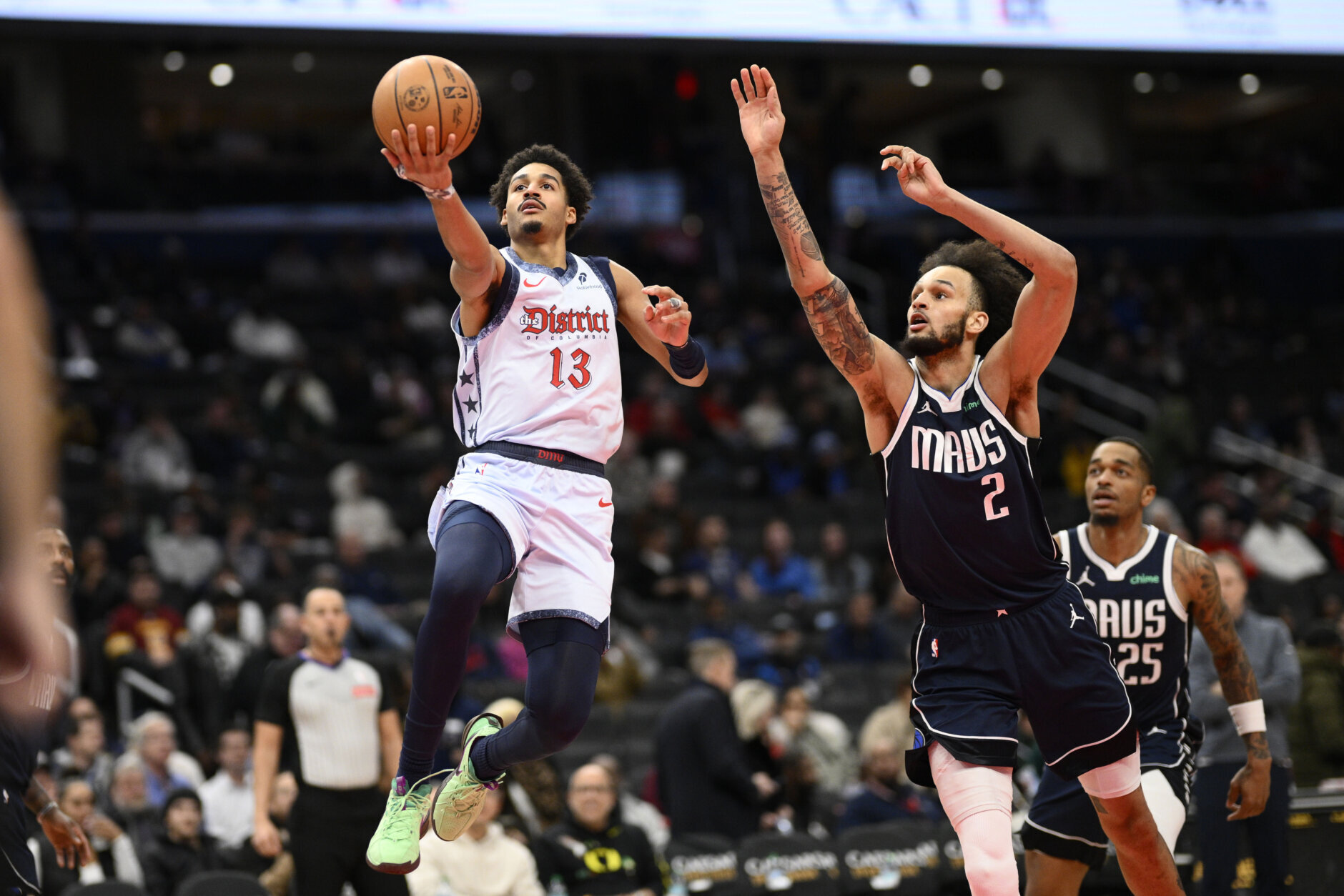 Washington Wizards guard Jordan Poole (13) goes to the basket against Dallas Mavericks center Dereck Lively II (2) during the first half of an NBA basketball game, Thursday, Dec. 5, 2024, in Washington. (AP Photo/Nick Wass)