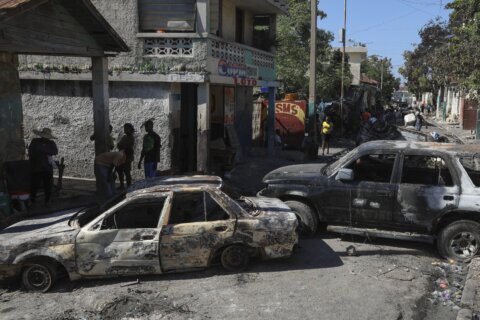 A Haiti gang attack on the reopening of a main hospital kills 2 reporters and a police officer