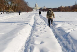 TOPSHOT - People walk through the snow-covered National Mall in Washington on December 20, 2009. A ferocious snow storm blanketed much of the eastern United States, cutting power to hundreds of thousands of homes, paralyzing air traffic and stranding motorists. The governors of Virginia, Maryland, West Virginia and Delaware declared states of emergency in advance of the storm, the worst to hit the region in decades.           AFP PHOTO/Nicholas KAMM (Photo by Nicholas KAMM / AFP) (Photo by NICHOLAS KAMM/AFP via Getty Images)