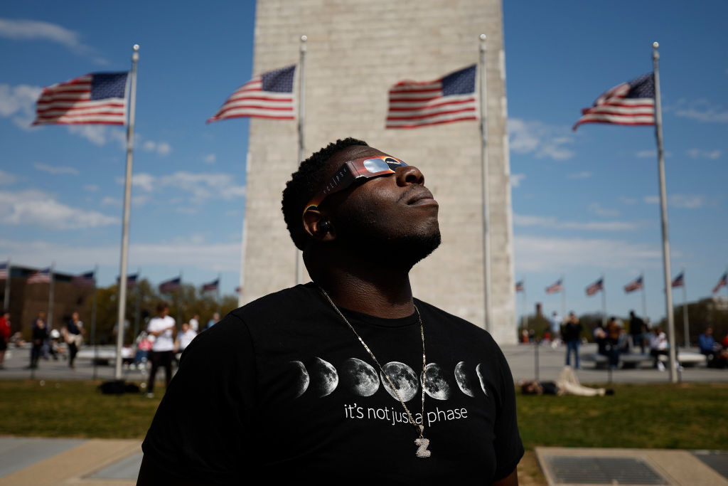 man stares at eclipse with glasses