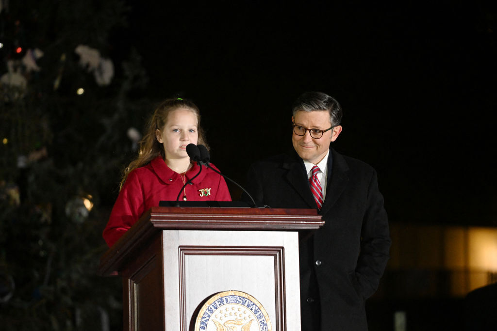 Mike Johnson, the Speaker of the US House of Representatives, looks at Rose Burke as she recites her essay about the tree during the lighting ceremony of the US Capitol Christmas Tree on Capitol Hill in Washington, DC, on December 3, 2024.