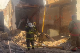 DC Firefighters and First responders stand and dig through rubble