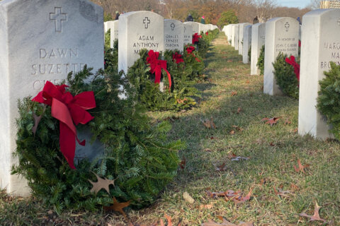 Green wreaths on white headstones for as far as the eye can see at Arlington National Cemetery